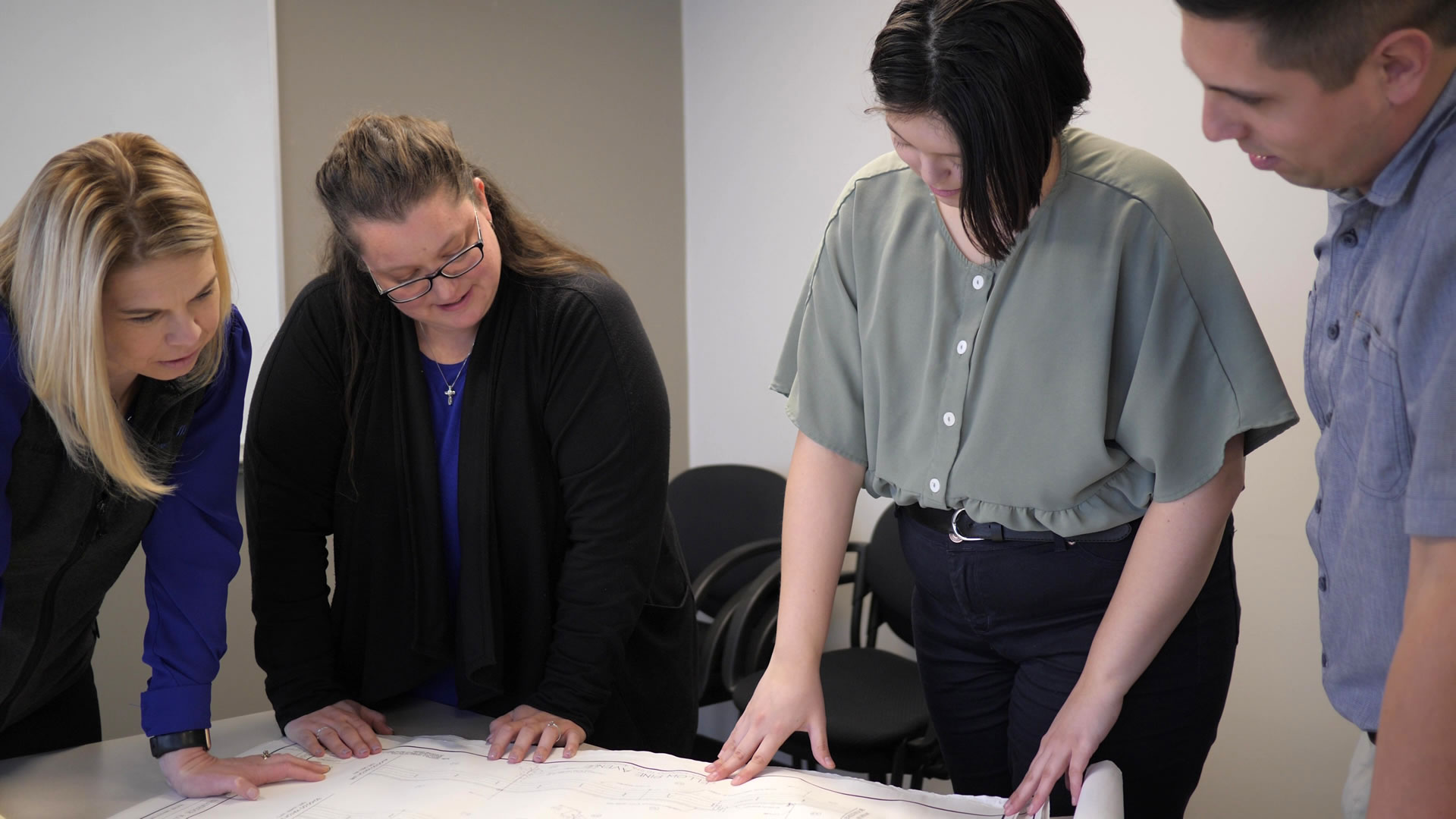 internship-P1333767 employees and intern reviewing prints
